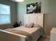 Cozy bedroom featuring a white bed frame, soft linens, and a decorative floral photograph at 5179 Royal Point Ave, Kissimmee, FL 34746