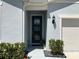 Stylish blue front door with lush greenery, and attached garage at 5179 Royal Point Ave, Kissimmee, FL 34746