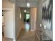 Hallway with tile flooring leading to open living spaces, decorated with a glass console table and art at 5179 Royal Point Ave, Kissimmee, FL 34746