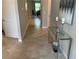 Hallway with tile flooring leading to open living spaces, decorated with a glass console table and art at 5179 Royal Point Ave, Kissimmee, FL 34746