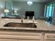 Close-up of granite countertop with stainless sink, with an open-concept floor plan in the background at 5179 Royal Point Ave, Kissimmee, FL 34746