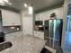 Well-equipped kitchen with stainless steel appliances, modern lighting, and a granite-topped island for meal prep at 5179 Royal Point Ave, Kissimmee, FL 34746