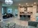 Open living area with granite island, kitchen, dining area and living room with elegant lighting at 5179 Royal Point Ave, Kissimmee, FL 34746