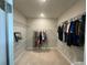 Bright and airy walk-in closet, featuring shelving, hanging space, and carpeted floors for organized storage at 5179 Royal Point Ave, Kissimmee, FL 34746