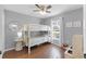 Bedroom showcasing a bunk bed, wood floors, and a window with natural light, and a round mirror at 52 Bay Ridge Loop, Mascotte, FL 34753