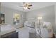 Bedroom featuring a crib, changing table, accent chair, and a window with plenty of natural light at 52 Bay Ridge Loop, Mascotte, FL 34753