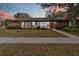 Charming one-story home featuring a brick facade, well-maintained lawn, and a welcoming red front door at 5359 Lanyard Ct, Winter Park, FL 32792