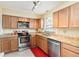 Well lit kitchen featuring stainless steel appliances, granite countertops and wood cabinets at 5359 Lanyard Ct, Winter Park, FL 32792