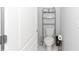 Small bathroom shows a toilet, storage rack, and white door at 5590 Forest Ridge Dr, Winter Haven, FL 33881