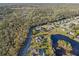 Aerial view of a house showcasing its location nestled within lush greenery and near a tranquil lake at 642 Osprey Lakes Cir, Chuluota, FL 32766