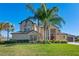 Beautiful two-story home featuring a well-manicured lawn, mature palm trees, and a welcoming facade at 642 Osprey Lakes Cir, Chuluota, FL 32766