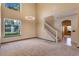 Bright living room featuring plush carpet, a modern chandelier, and stairs leading to the second floor at 642 Osprey Lakes Cir, Chuluota, FL 32766