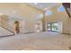 Spacious living room with high ceilings, plush carpet, and sliding glass doors to the pool area at 642 Osprey Lakes Cir, Chuluota, FL 32766