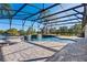 A wide view of the screened in pool with interlock stone decking and hot tub at 642 Osprey Lakes Cir, Chuluota, FL 32766