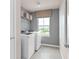 Laundry room featuring washer and dryer with shelving and a window for natural light at 7054 Rosy Sky Ave, Orlando, FL 32829