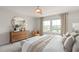 Spacious main bedroom featuring a luxurious bed, accent chair, and abundant natural light from the large windows at 7054 Rosy Sky Ave, Orlando, FL 32829