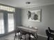 Bright dining area featuring a modern chandelier, grey decor, and natural light from the French doors at 770 Siena Palm Dr # 201, Kissimmee, FL 34747