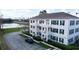 Exterior view showcasing the building's balconies, lush landscaping, and a glimpse of the pond at 770 Siena Palm Dr # 201, Kissimmee, FL 34747