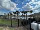 Community pool area, with palm trees, fencing, and clear blue skies at 777 Orchid Grove Blvd, Davenport, FL 33837