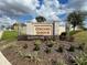 Stone sign reading 'Orchid Grove' surrounded by landscaping and clear blue skies at 777 Orchid Grove Blvd, Davenport, FL 33837