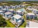 Community aerial shot showcasing a pool, modern residences with manicured lawns under a clear blue sky at 7770 Sandy Ridge Dr # 110, Reunion, FL 34747