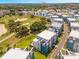 Aerial view of a neighborhood with modern architecture, golf course and lush landscaping under a sunny sky at 7770 Sandy Ridge Dr # 110, Reunion, FL 34747