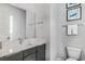 Well-lit bathroom features modern vanity with white countertop, gray cabinets, a large mirror, and a toilet at 7770 Sandy Ridge Dr # 110, Reunion, FL 34747