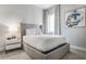 Comfortable bedroom with a gray upholstered bed frame, neutral decor, and natural lighting at 7770 Sandy Ridge Dr # 110, Reunion, FL 34747