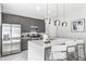 Bright modern kitchen with stainless steel appliances, island seating, and gray cabinetry at 7770 Sandy Ridge Dr # 110, Reunion, FL 34747