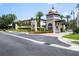 Elegant community entrance with manicured landscaping, decorative gatehouse, and attractive street view at 8125 Via Vittoria Way, Orlando, FL 32819