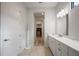 Neutral colored hallway bathroom with tile floors, white cabinets, and quartz counters at 8125 Via Vittoria Way, Orlando, FL 32819