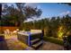 Inviting backyard featuring a modern hot tub with LED lighting, seating area, and manicured greenery at 8125 Via Vittoria Way, Orlando, FL 32819