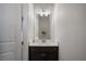 Small powder room features a dark wood cabinet and is brightly lit with white walls at 8125 Via Vittoria Way, Orlando, FL 32819