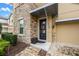 Close up of front door with stone siding, stylish overhead protection, and a charming wreath at 9030 Sunshine Ridge Loop, Kissimmee, FL 34747