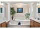 Luxurious bathroom with a soaking tub, dual sinks, and decorative columns at 932 Classic View Dr, Auburndale, FL 33823