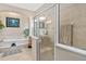 Bathroom features a glass enclosed shower, soaking tub with white marble steps and cherry wood vanity at 932 Classic View Dr, Auburndale, FL 33823