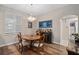 Bright dining room features wood floors, modern chandelier, bar and seating for four at 932 Classic View Dr, Auburndale, FL 33823