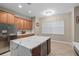 Open kitchen with stainless steel refrigerator and island with wine storage and marble countertops at 932 Classic View Dr, Auburndale, FL 33823