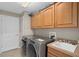 Laundry room with modern washer and dryer, sink, and ample cabinet space at 932 Classic View Dr, Auburndale, FL 33823