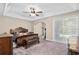 Spacious main bedroom with a tray ceiling, large windows, and an elegant wood bed at 932 Classic View Dr, Auburndale, FL 33823