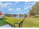 Backyard view of a tranquil pond with a fountain, surrounded by green lawns and neighborhood houses at 1311 Travertine Ter, Sanford, FL 32771