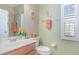 Bright bathroom featuring single sink vanity, toilet, and shower with decorative accents at 1311 Travertine Ter, Sanford, FL 32771
