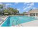 Community swimming pool with clear blue water, lounge chairs, covered cabanas, and palm trees at 1311 Travertine Ter, Sanford, FL 32771