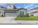 Gray home with a large two-car garage, trimmed hedges, and well-kept lawn at 1311 Travertine Ter, Sanford, FL 32771