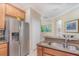 Bright kitchen featuring stainless steel refrigerator, granite countertops, and a sink overlooking the breakfast bar at 1311 Travertine Ter, Sanford, FL 32771