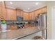 Well-equipped kitchen with stainless steel appliances, granite counters, tile backsplash, and a breakfast bar at 1311 Travertine Ter, Sanford, FL 32771