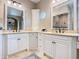 Bathroom featuring double sinks with granite counters, cream cabinets, and a unique round window at 13463 Bonica Way, Windermere, FL 34786