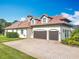 Three car garage, featuring an expansive driveway and meticulously maintained landscaping at 13463 Bonica Way, Windermere, FL 34786