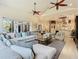 Open concept living room with high ceilings, ceiling fans, stylish furniture, and access to the lanai at 13463 Bonica Way, Windermere, FL 34786