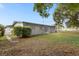 Backyard of the property showing the house, grass, and trees at 1407 Dunsany Ave, Orlando, FL 32806